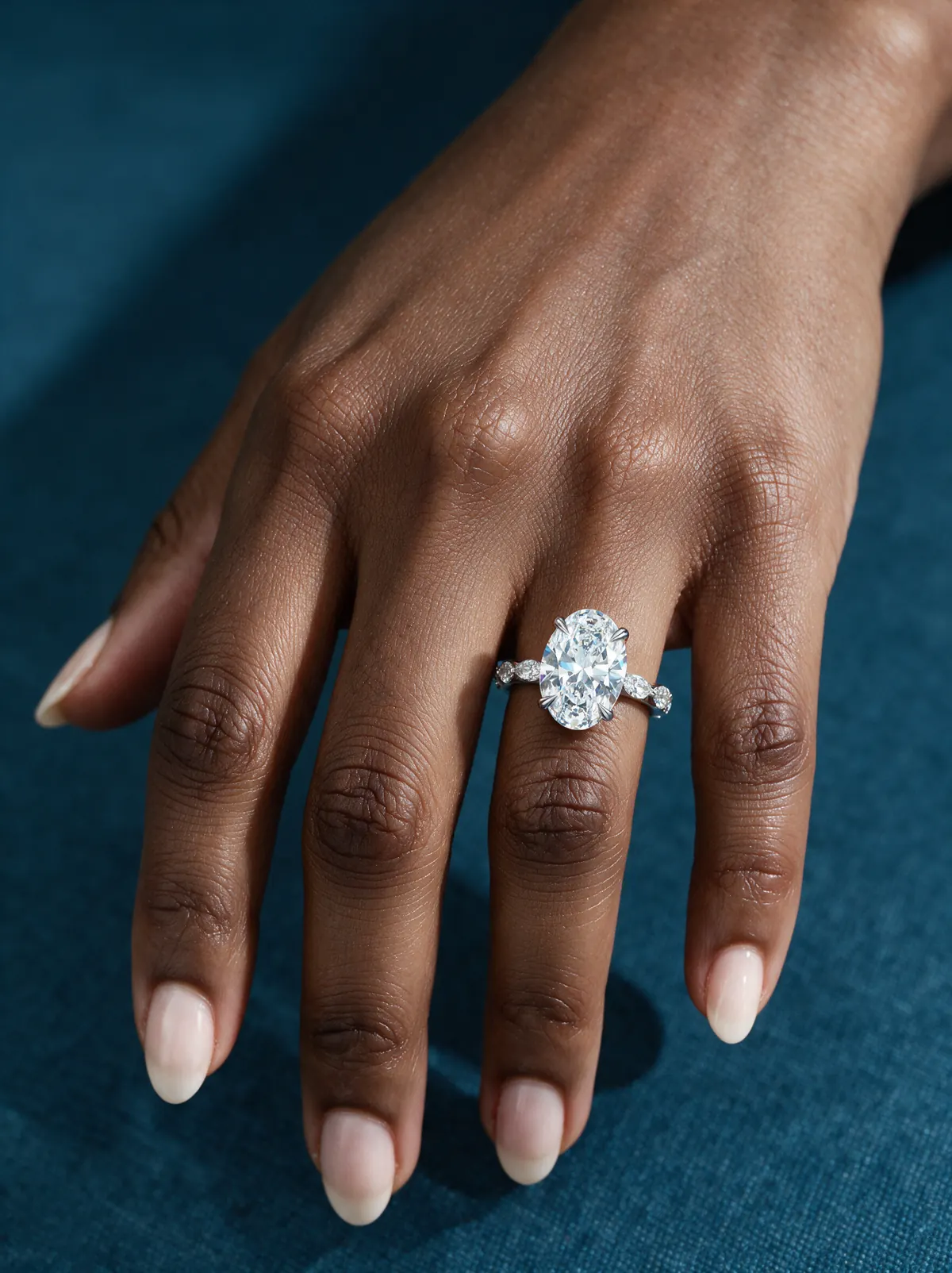 Oval lab-grown diamond solitaire on a marquise band, worn on hand